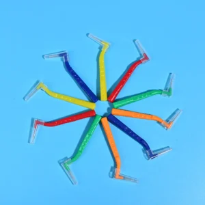 Multicolor rainbow L-type interdental cleaners arranged radial star shape on solid light blue background, color coded for different ISO sizes