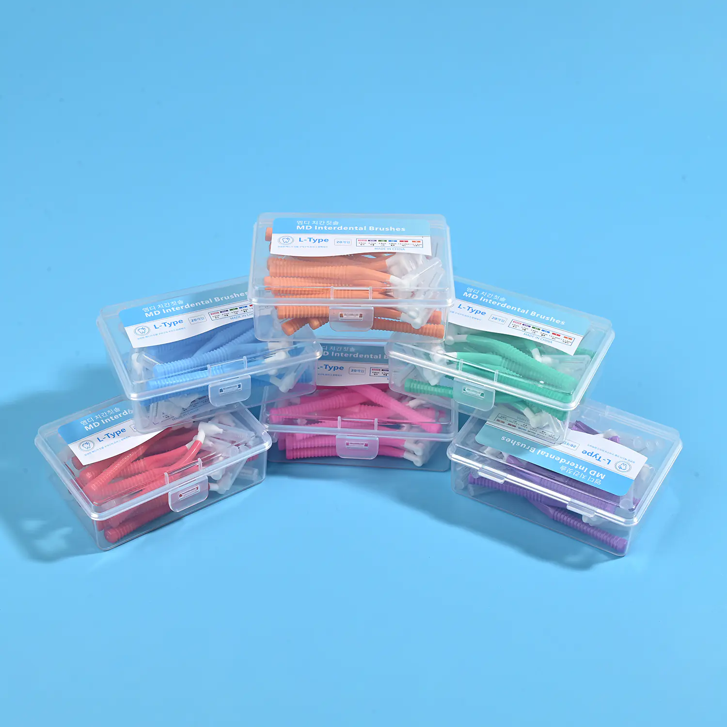 assorted multi color L-type MD interdental brush boxes stacked on blue background, full ISO size color coded dental gap cleaners